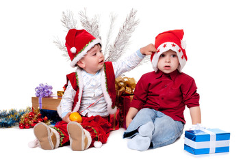 Obraz premium Two kids in Santa hats beside Christmas tree