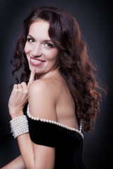 Naklejka premium Beautiful brunette woman over dark background