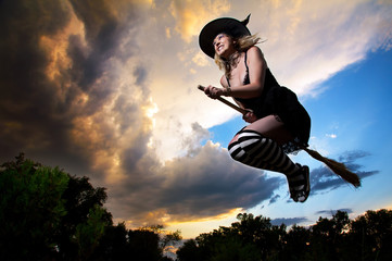 Flying witch in dramatic sky