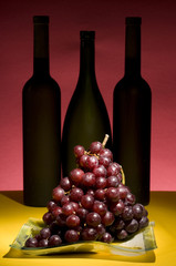 Red grape and wine bottle still life