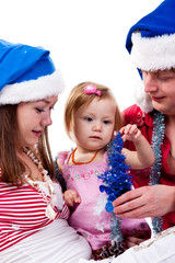 Family in Santa's hat sitting in artificial snow