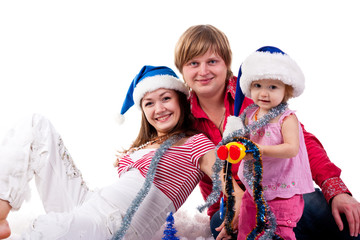 Fototapeta na wymiar Family in Santa's hat sitting in artificial snow