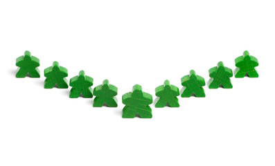 Large wooden figure among smaller ones symbolizing leadership