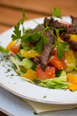 Grilled beef with vegetables on a white plate