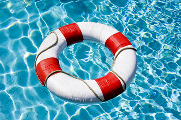 Life ring floating on top of sunny blue water
