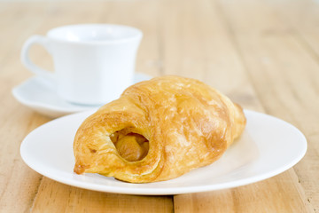 A cup of black coffee with Plate of sausage rolls