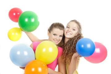 Fototapeta na wymiar two smiling girls with balloons over white