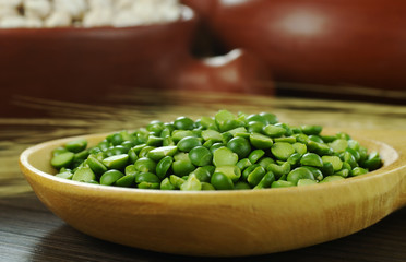 Dried green peas on wooden spoon