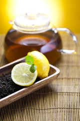 Glass teapot of tea with lemon
