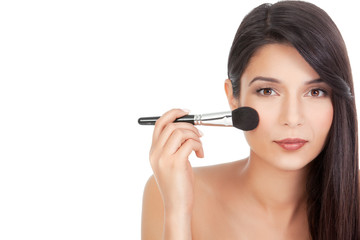 beauty portrait of a young woman applying blush