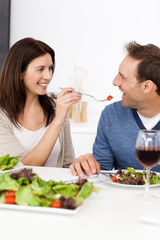 Passionate woman giving a tomato to her boyfriend while having l