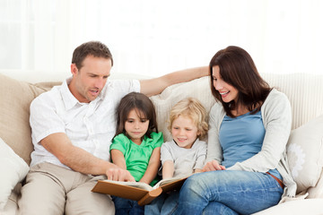 Obraz premium Happy family looking at a photo album together