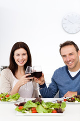 Lovely couple drinking red wine while having lunch