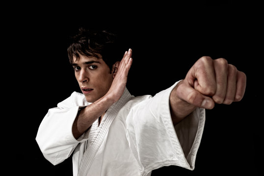 Karate male fighter young close-up high contrast on black