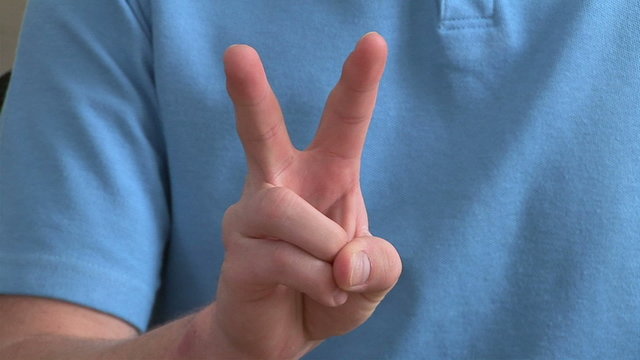 Close up of male giving the peace sign