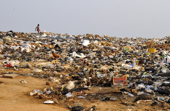 Kind läuft über Müllkippe in Afrika