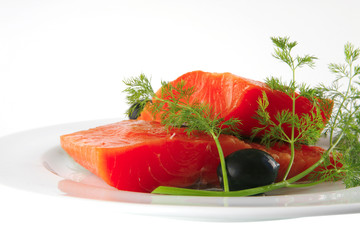 fresh smoked salmon on white plate with olives