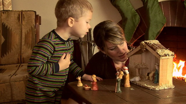 Mother and son with nativity scene at Christmas