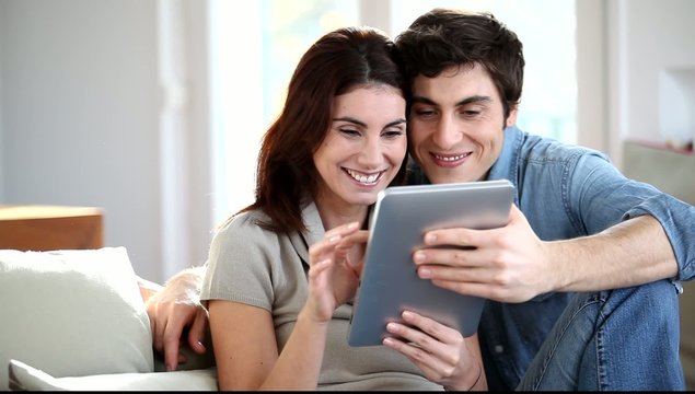 Couple surfing on internet with electronic tab