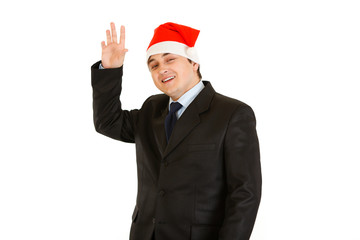 Friendly young businessman in hat of Santa Claus.