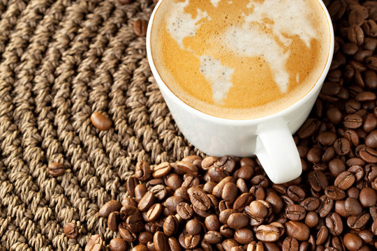 Cup of cappuccino with world map formed by milk foam