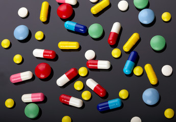 Colorful pills over dark background