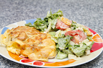 chicken breast baked under cheese with salad