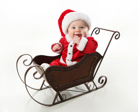 Smiling santa baby sitting in a sleigh