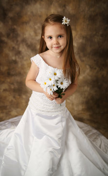 Little girl trying on mommy's wedding dress