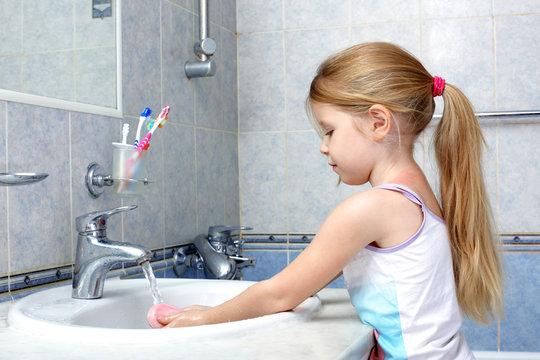 Little girl washing in bathroom