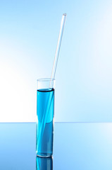 Test tube on blue background. With glass stick