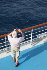 man with photo camera standing on deck of cruise ship