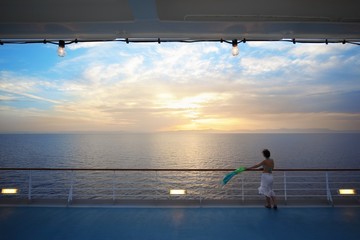 woman with kerchief standing on deck of cruise ship