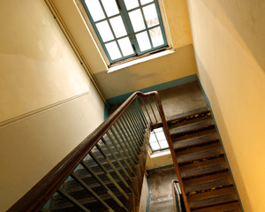 Looking down at an old wooden stairs at an abandoned building © leungchopan
