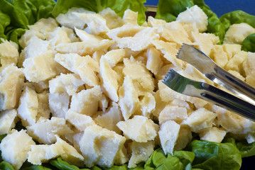 Vassoio con tocchi di formaggio parmigiano su lattuga