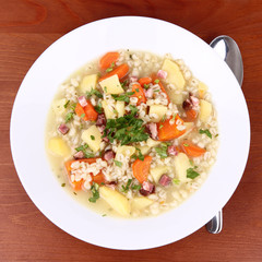 Barley soup on a wooden background