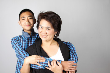 Teenage boy with funny face hugging his mother/auntie.