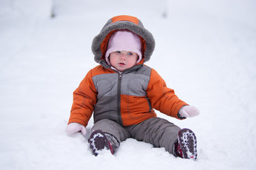 cute baby sit on fresh snow in park