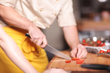 Koch schneidet Tomate
