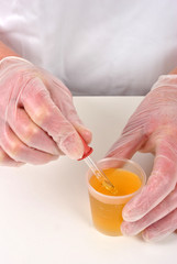 Pipette neben Messbecher mit Flüssigkeit