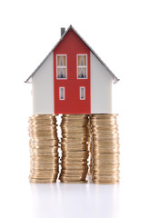 Mortgage concept. House at the top of coins.