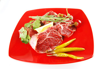 uncooked meat medallion on red