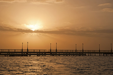 Sunrise over the ocean at a pier