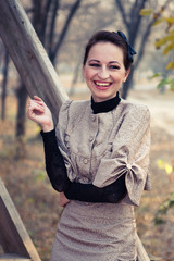 A woman in an old dress on a walk near the wooden railing