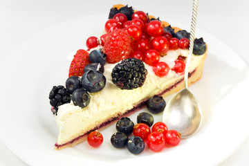 Piece of a pie with fresh berries on a plate