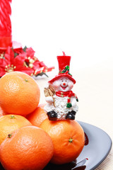 Pile of tangerines, Snowman candle with christmas decoration