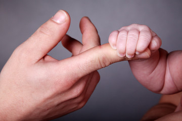 Baby greift einen Finger closeup