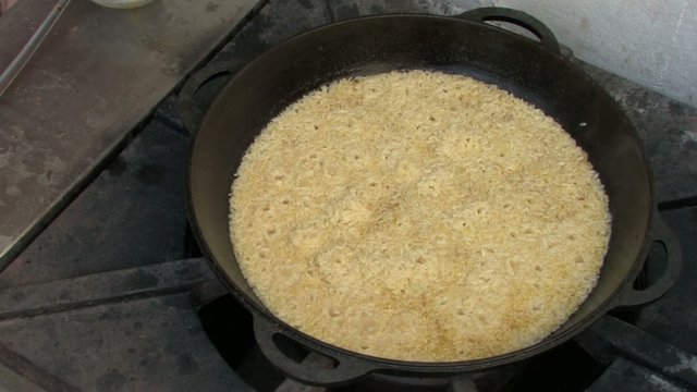 Cauldron with Bubbling pilaf on Stove, Closeup