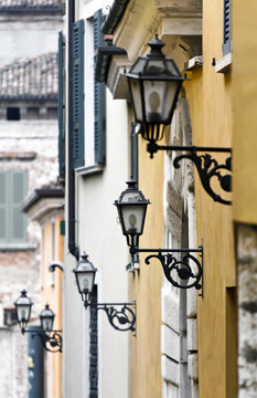Five street lamps along a street in Brescia city