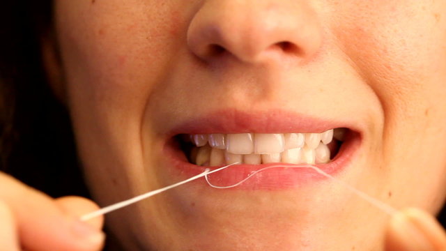 woman using dental floss